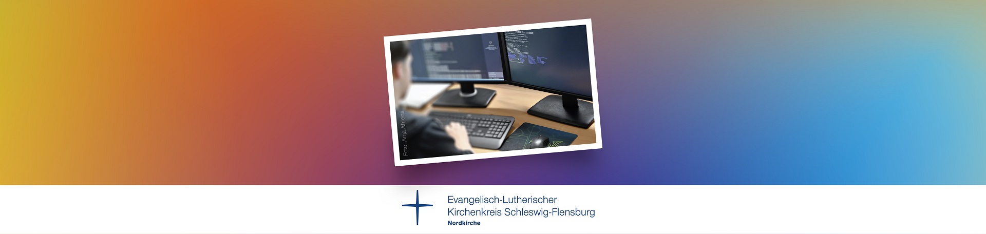 Der Hintergrund wurde in Regenbogenfarben gestaltet. In der Mitte befindet sich ein Bild, das einen Mitarbeiter zeigt, der am PC ein System konfiguriert.